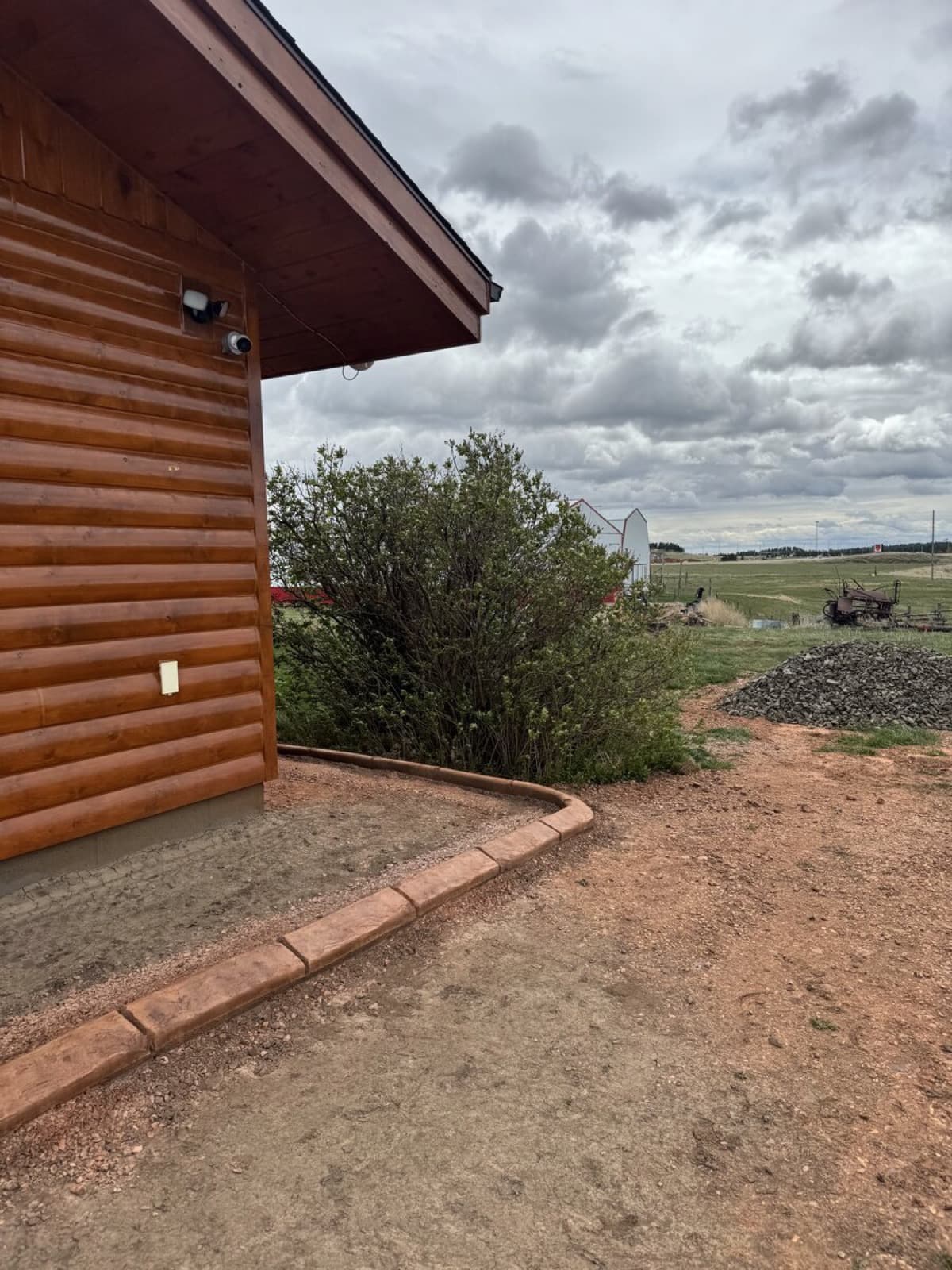 Custom curbing installation around a log cabin property in the Black Hills