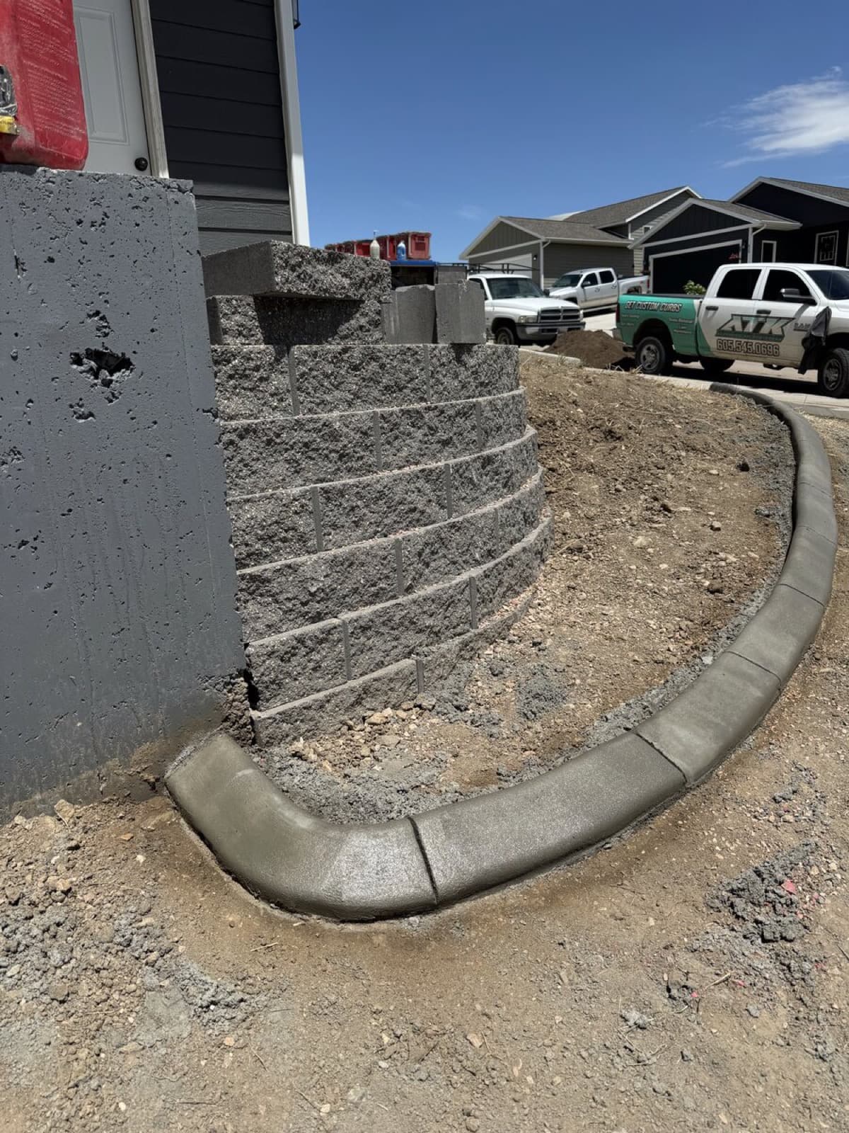 Stamped concrete curbing border defining flower beds in a Rapid City front yard