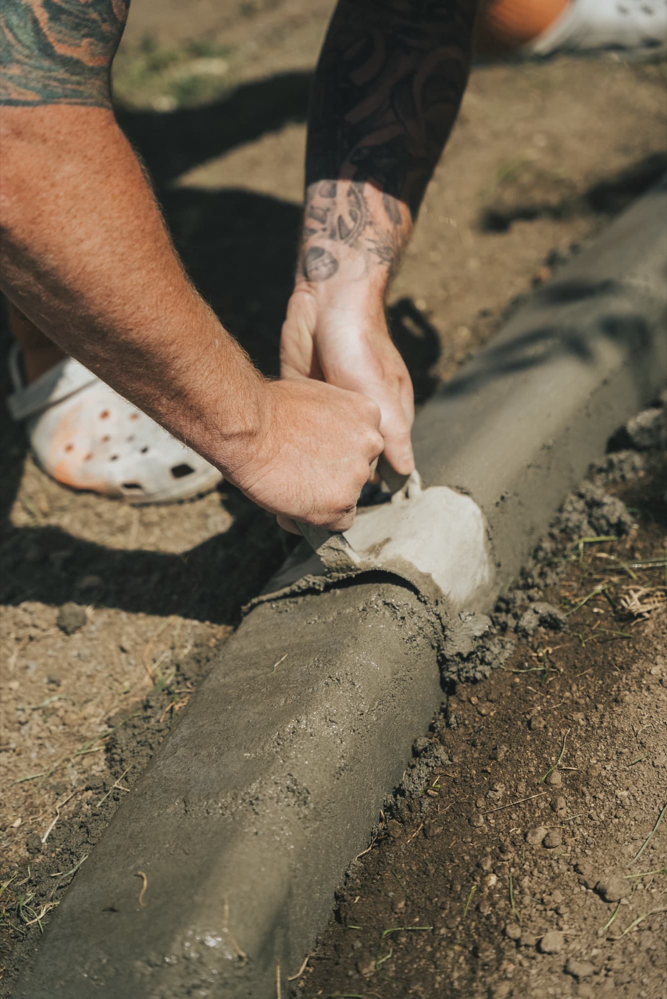 Close view of hands smoothing fresh landscape curbing