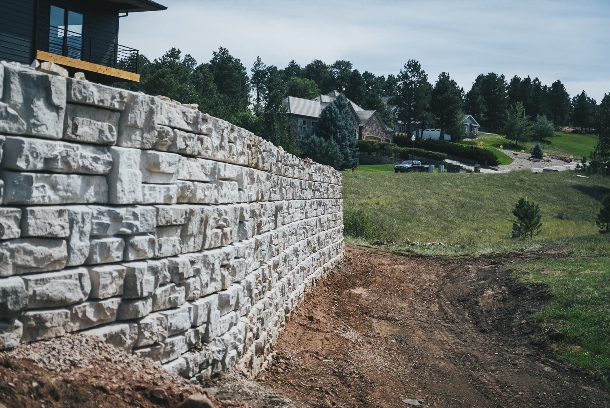 Close view along a textured block retaining wall beside a slope